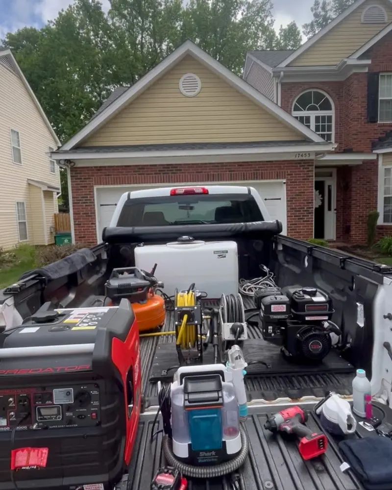 Pickup truck bed loaded with pressure washer, water tank and detailing equipment