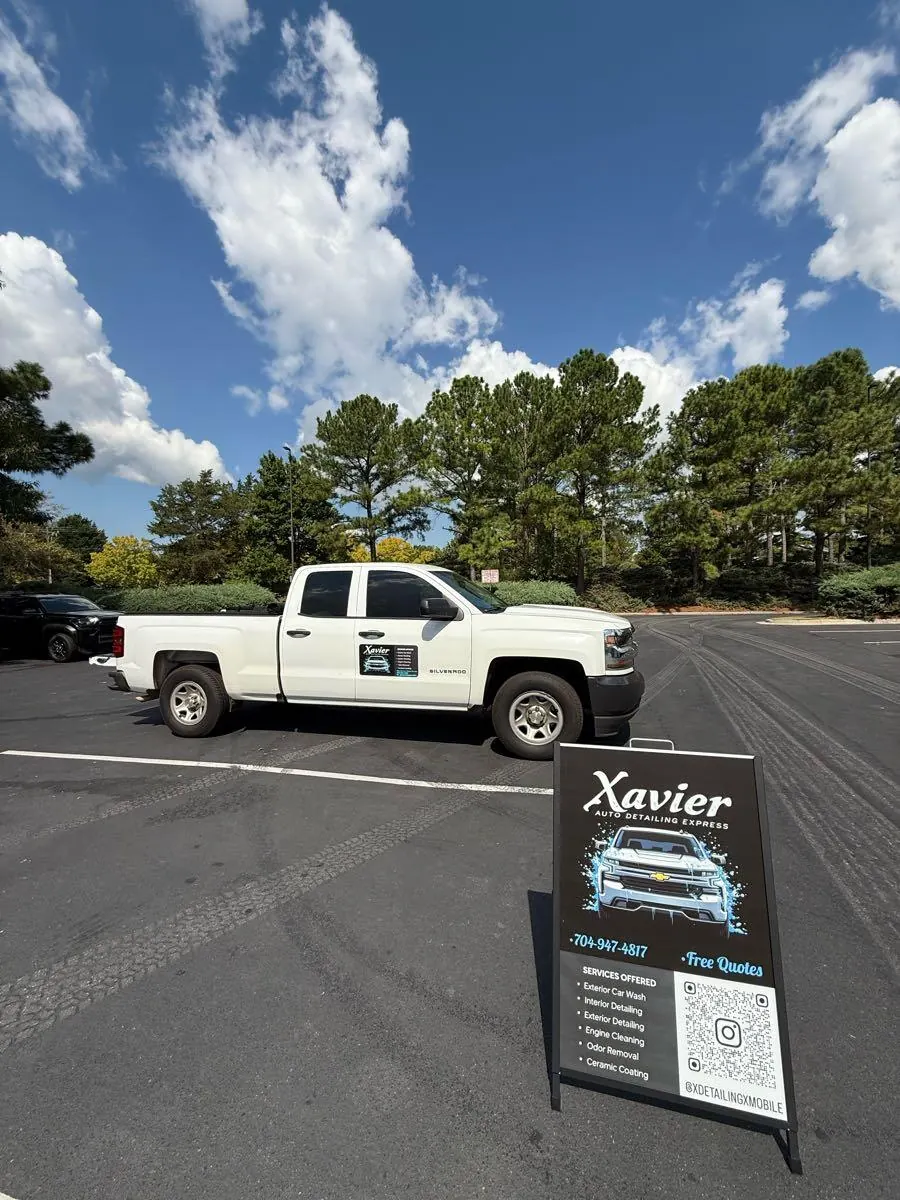 Xavier's white mobile detailing truck and business sign
